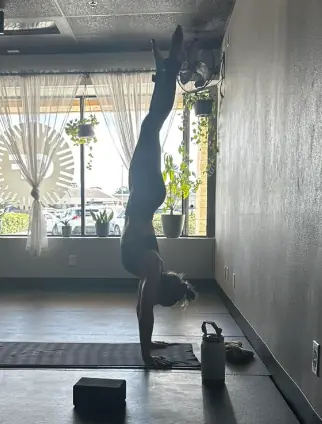 Student in a handstand in front of the studio windows